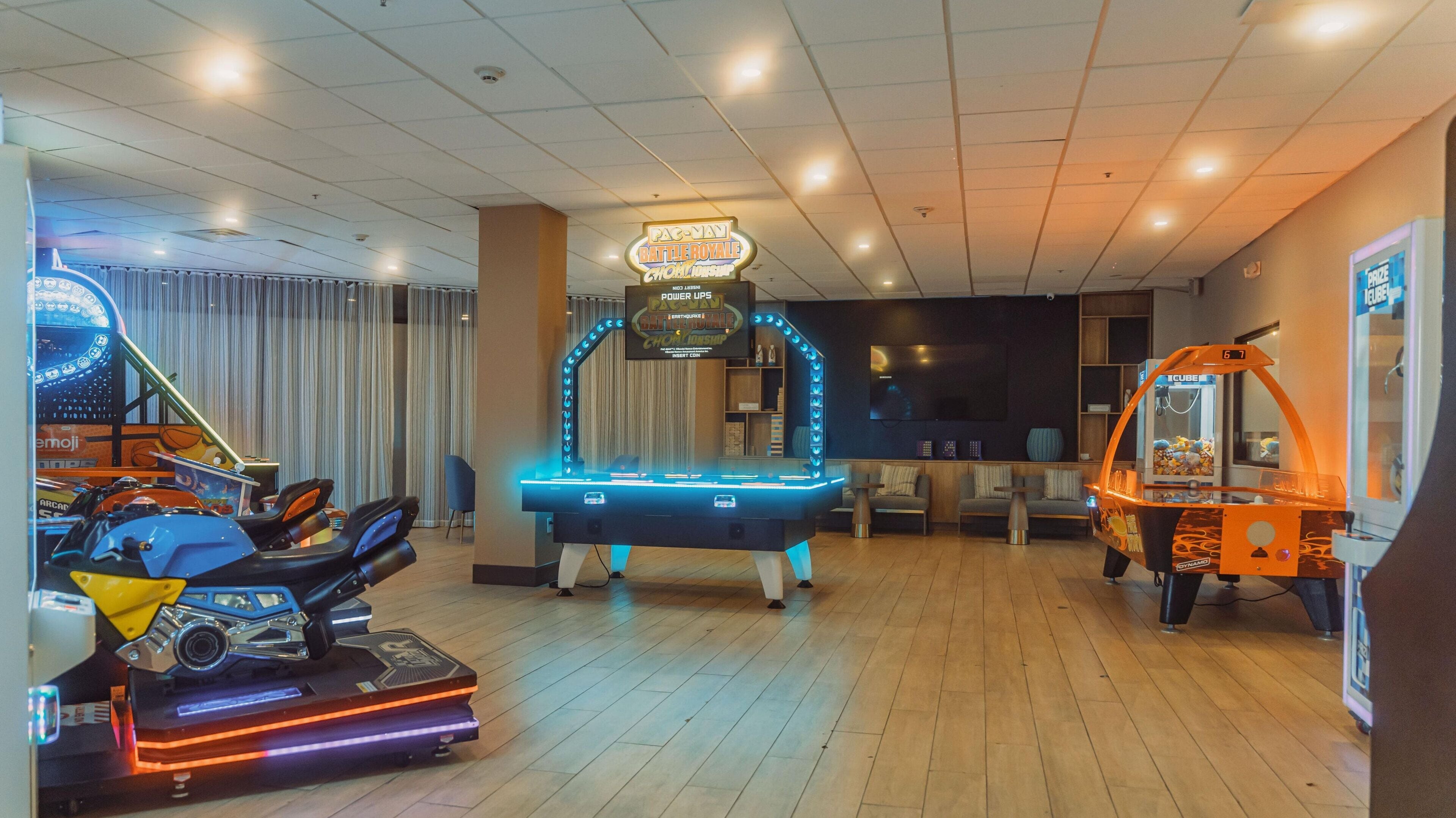 Eine Spielhalle mit verschiedenen Automaten, darunter Rennspiele und Flipperautomaten.