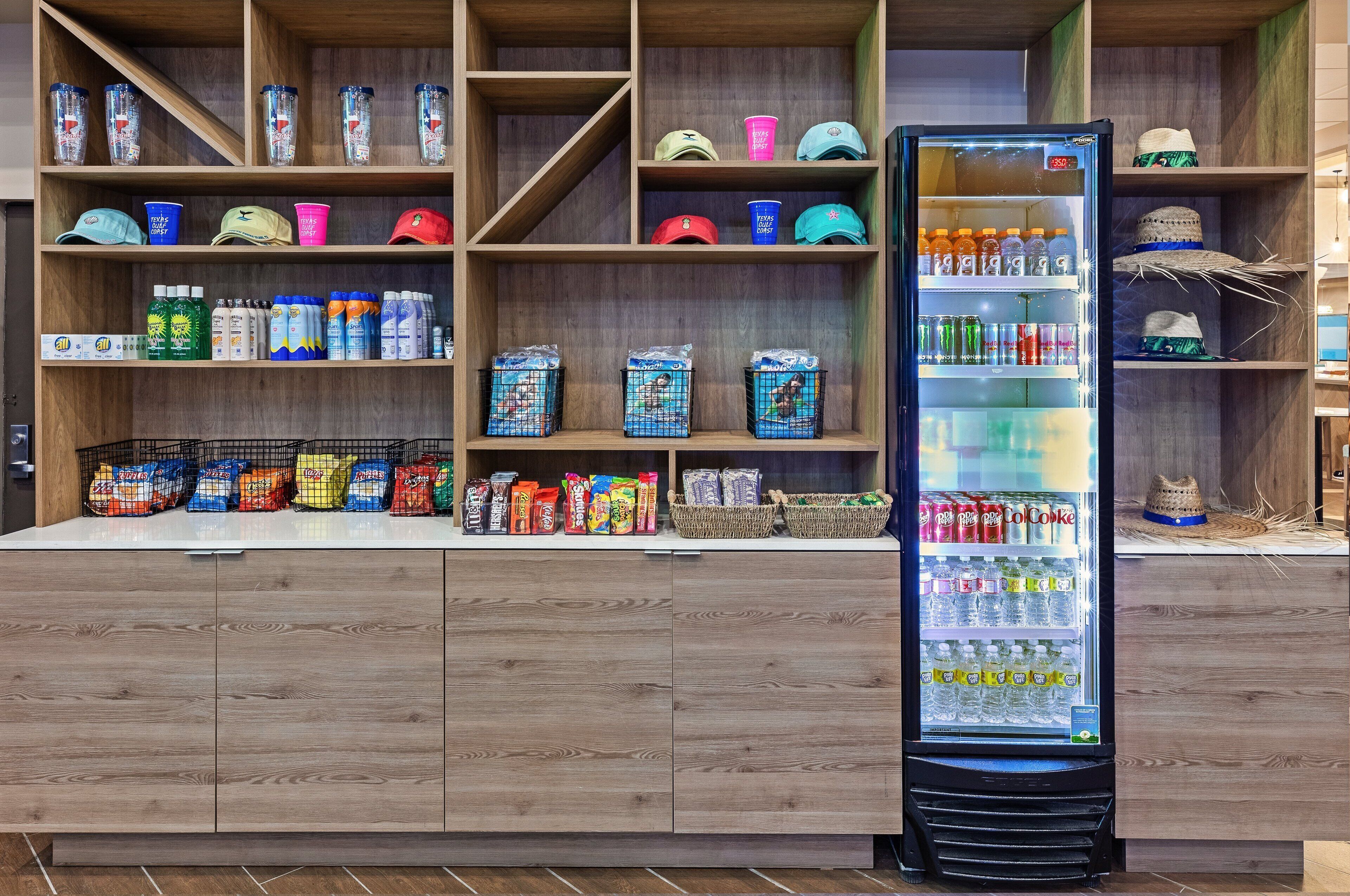 A vending area with a variety of beverages, snacks, and hats.
