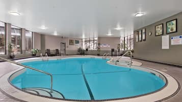 Una piscina techada, sillones reclinables de piscina