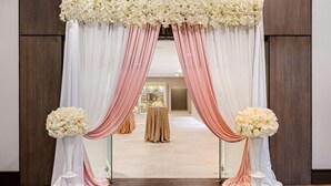 An entrance with white and pink drapes, a floral arch, and two flower stands. - Best Western Premier Calgary Plaza Hotel & Conference Centre (Calgary)