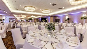 A banquet hall with round tables set for a formal event, featuring white tablecloths, silverware, and floral centerpieces. - Best Western Premier Calgary Plaza Hotel & Conference Centre (Calgary)