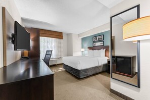 A hotel room with a bed, bedside table, lamp, and a television. - Sleep Inn State College near Penn State  (State College)