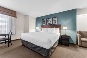 A hotel room with a bed, a desk, a chair, a nightstand, and a lamp. - Sleep Inn State College near Penn State  (State College)