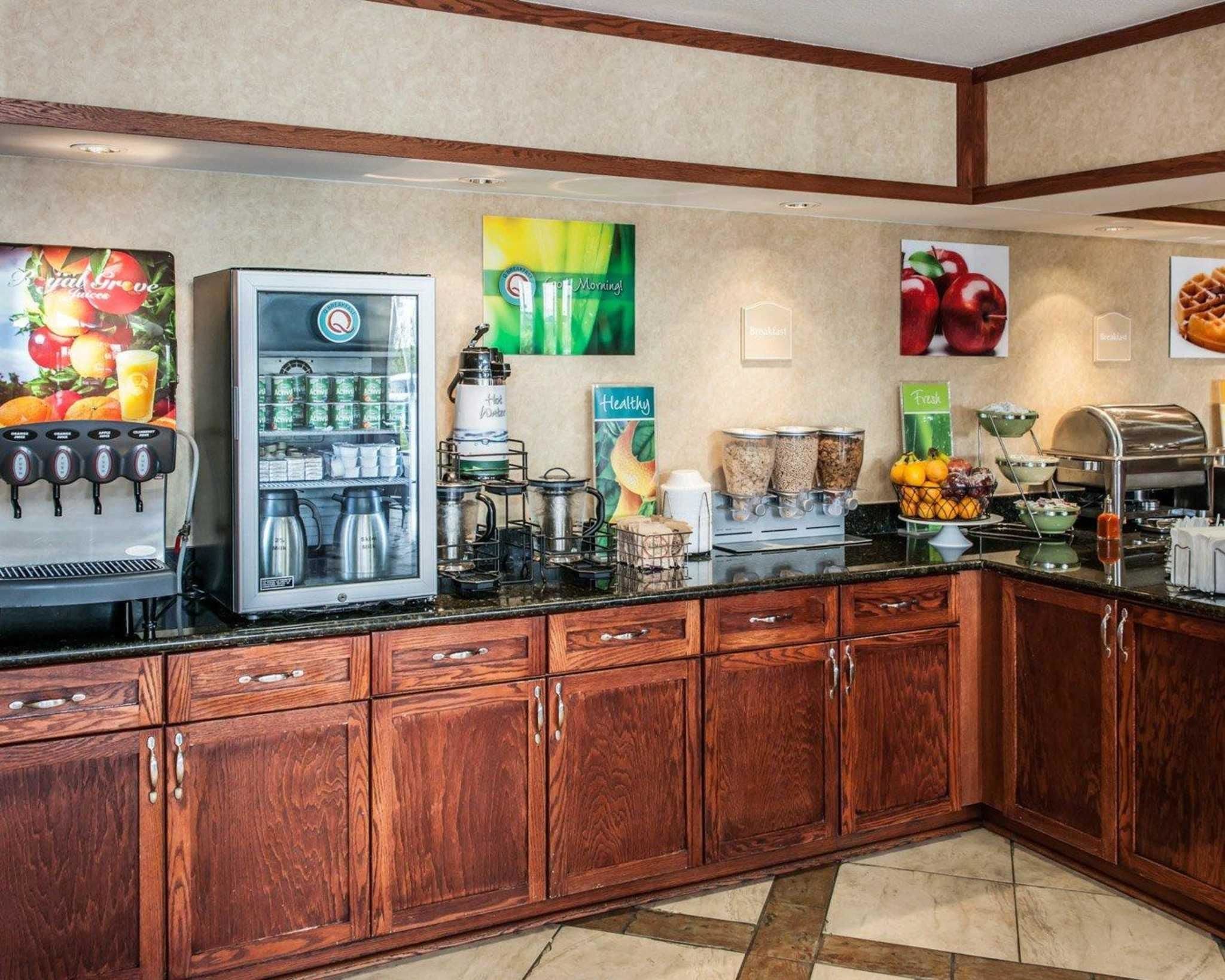 A breakfast bar with a coffee machine, refrigerated drinks, and various food containers.