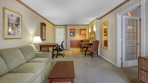 A hotel room with a sofa, a table, a desk, a chair, a kitchen area, and a door. - Best Western Plus Genetti Wilkes Barre (Wilkes-Barre)