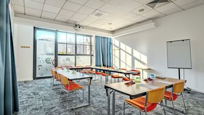 A conference room with tables and chairs, a whiteboard, and a large window with curtains. - ibis Marne La Vallée Champs (Champs-sur-Marne)