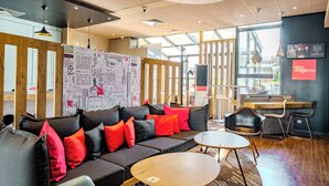 A modern interior with a sofa, round table, and wooden accents. - ibis Marne La Vallée Champs (Champs-sur-Marne)