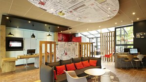 A modern interior with a sofa, chairs, a desk, and a TV.