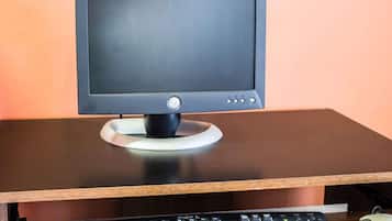 En computerskærm på et skrivebord med tastatur og mus.