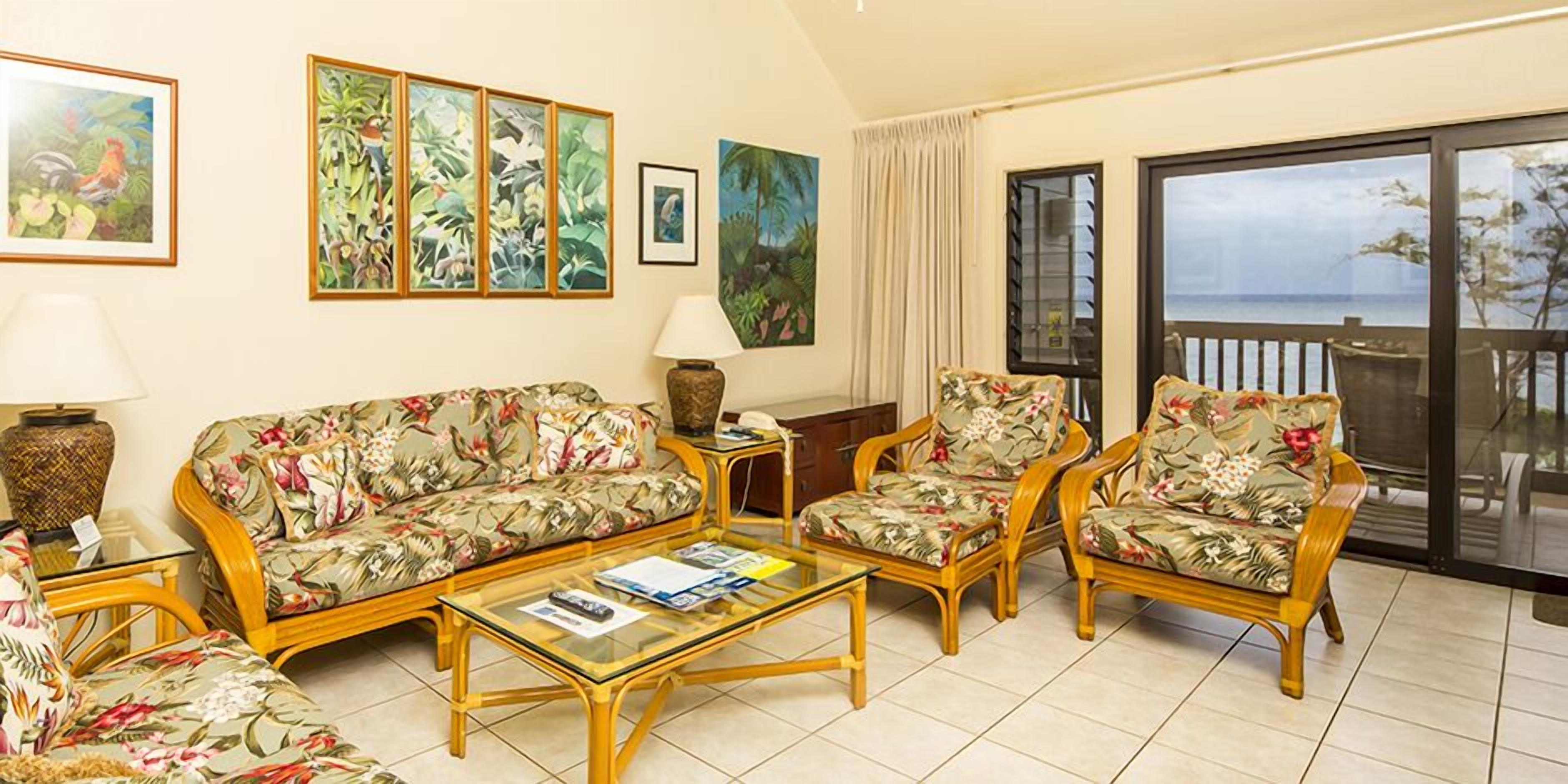 A living room with a sofa, armchairs, a coffee table, and artwork on the walls.