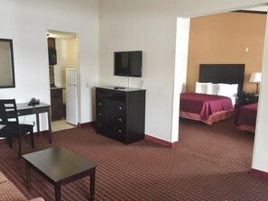 Cozy retreat with a single bed, desk, and kitchenette area.
