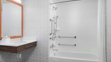 Une salle de bain moderne avec une douche à parois de verre, un meuble-lavabo en bois et un grand miroir.
