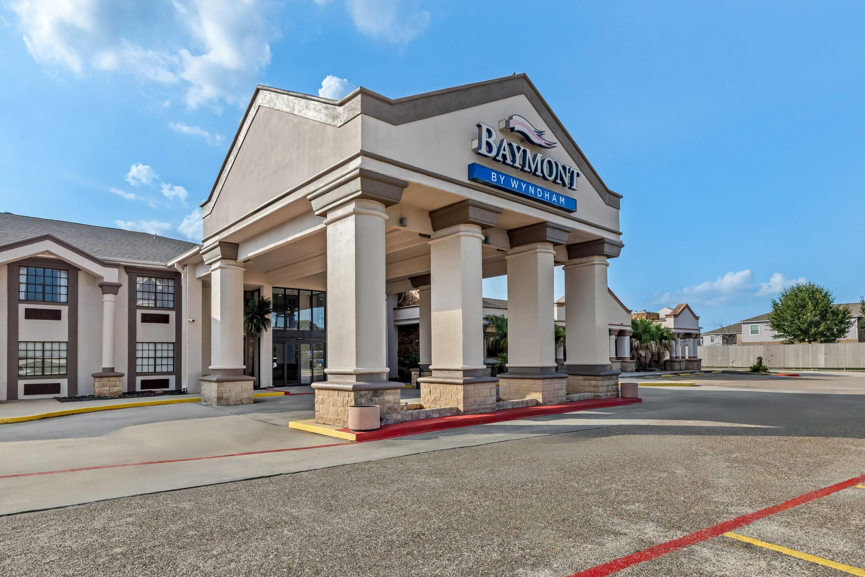 A hotel with a prominent entrance, columns, and a clear sky.