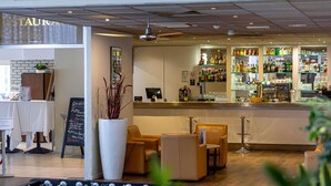 A bar area with seating, a foosball table, and a sign reading 'ESTAUKA'. - Mercure Paris Le Bourget (Le Blanc-Mesnil)