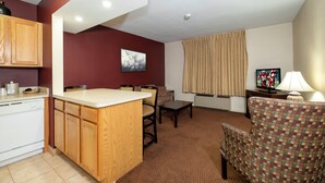 A compact hotel room with a kitchenette, a dining area, and a seating area with a television. - Red Roof Inn & Suites Hazleton (Hazleton)