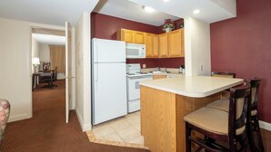 A compact kitchen with wooden cabinets, a white refrigerator, a microwave, and a stove. - Red Roof Inn & Suites Hazleton (Hazleton)