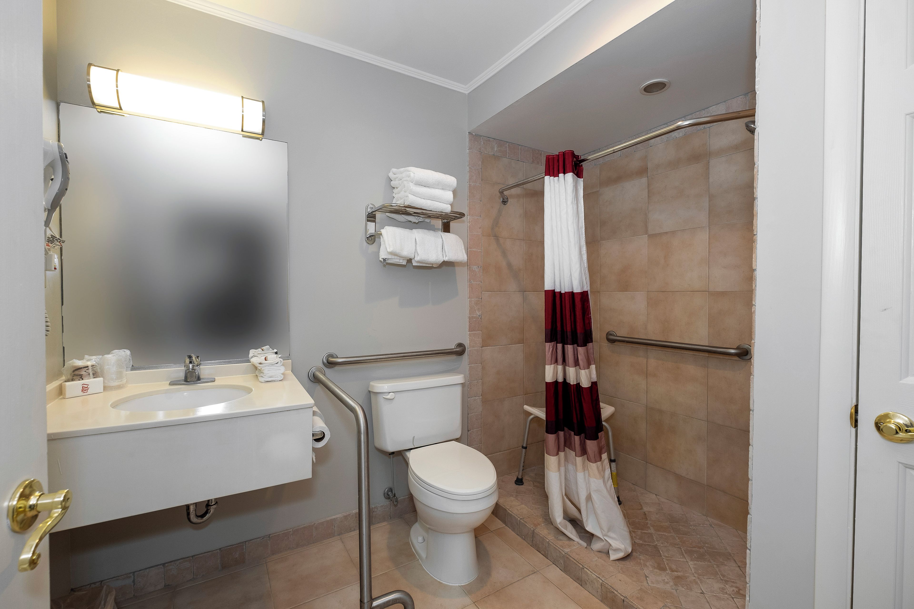 A bathroom with a white sink, toilet, and shower area.