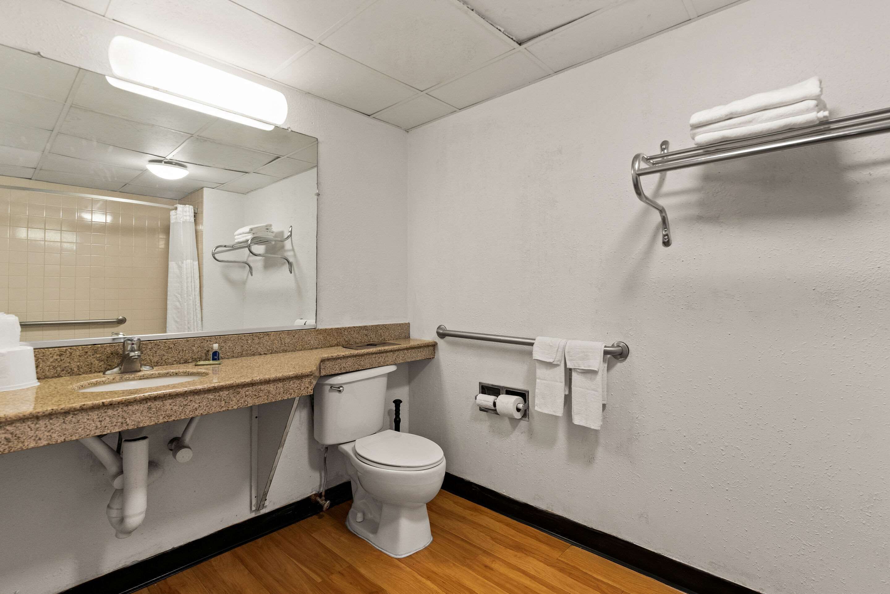 Ein Badezimmer mit Waschbecken, Toilette, Handtuchhalter und Spiegel.