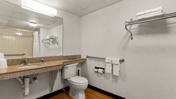 A bathroom with a sink, toilet, towel rack, and a mirror.