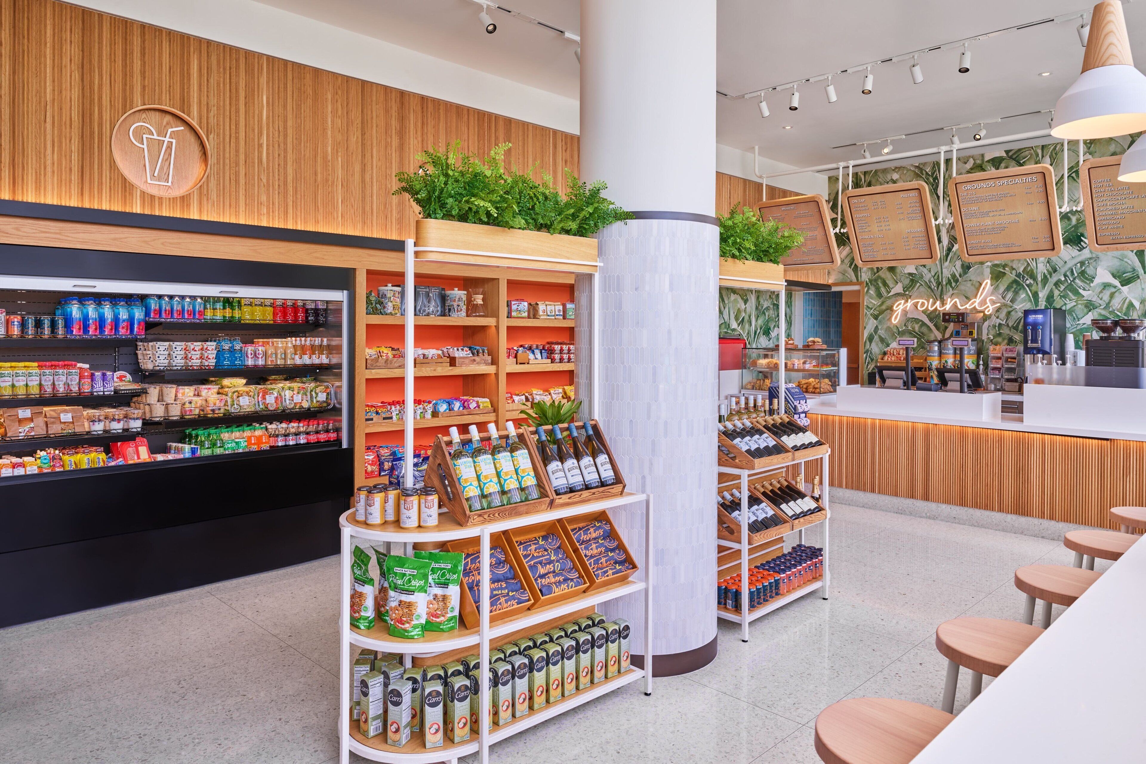 A modern grocery store interior with shelves stocked with beverages, snacks, and packaged goods.