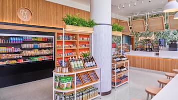 A modern grocery store interior with shelves stocked with beverages, snacks, and packaged goods.