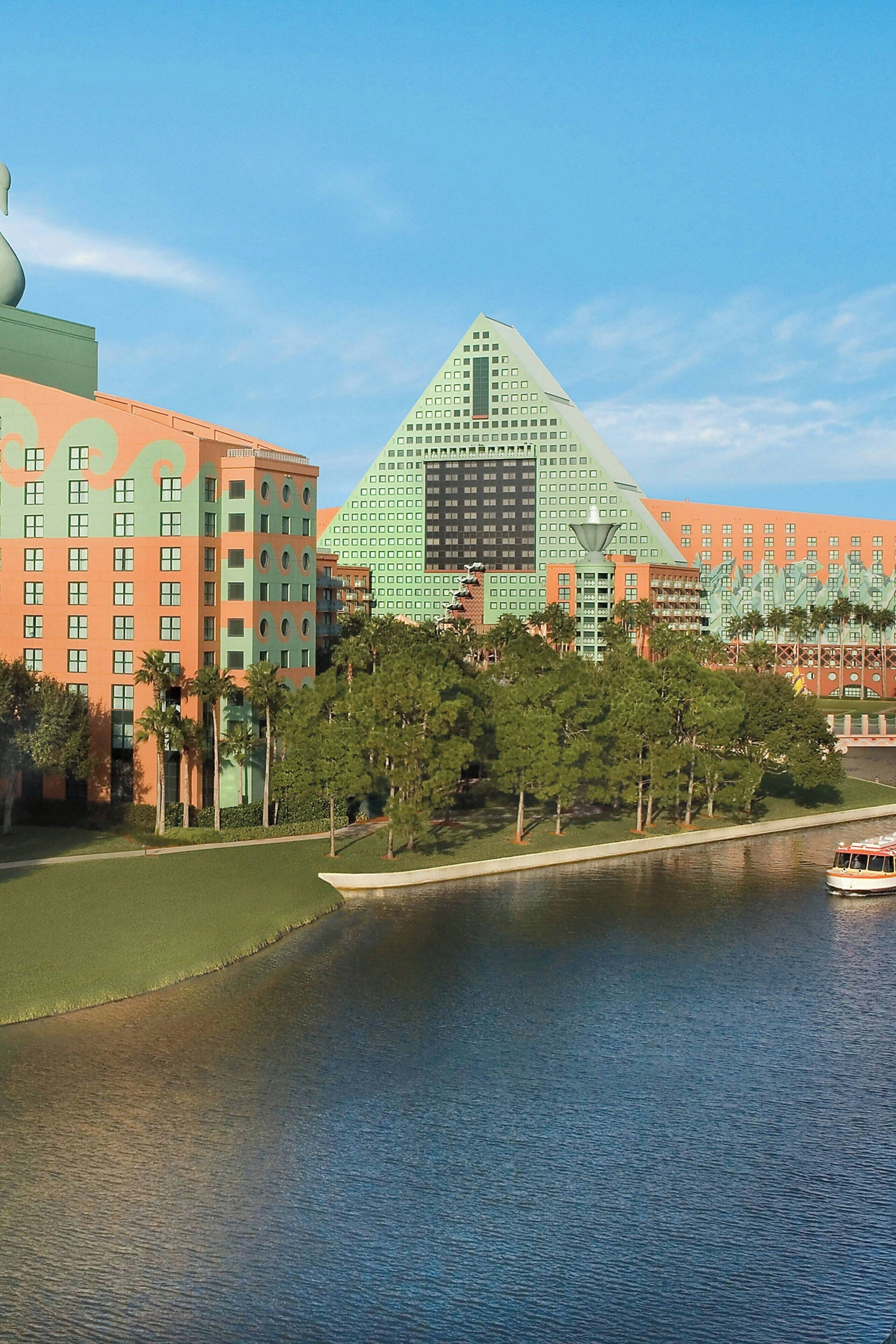 A large hotel with a distinctive pyramid-shaped building and a river in front.