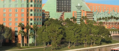 A large hotel with a distinctive pyramid-shaped building and a river in front.