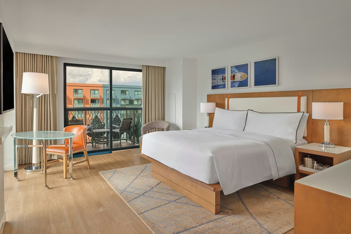 A hotel room with a bed, two bedside tables, a desk, and chairs.