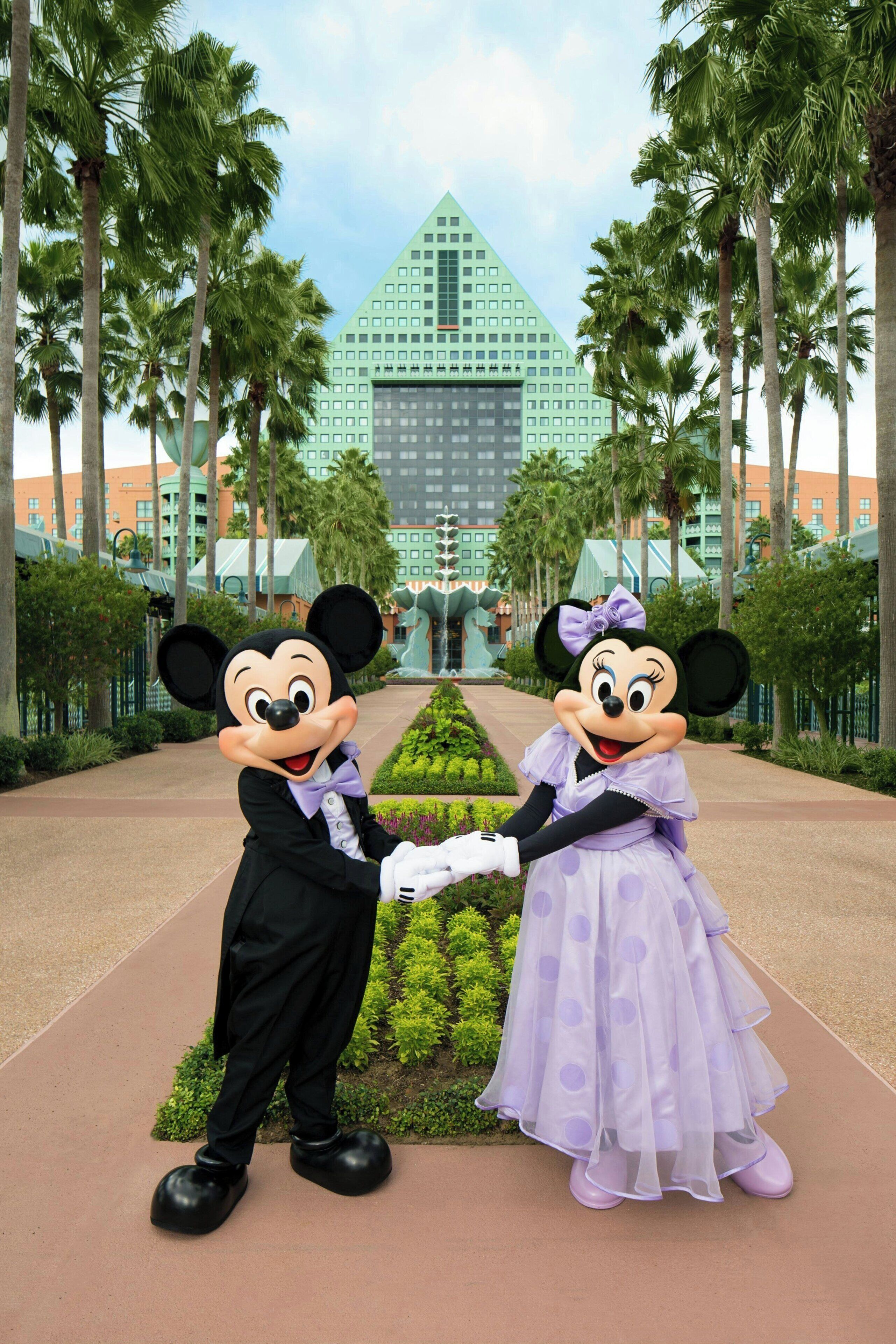 Mickey et Minnie Mouse se tiennent devant un bâtiment dont l’architecture ressemble à une pyramide.