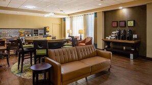 Un hall de hotel con zona de bar, asientos y estación de café.