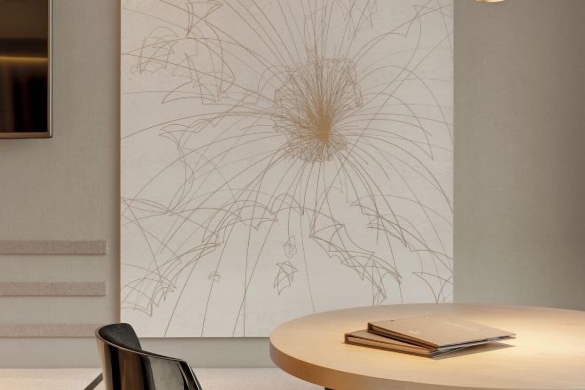 Une pièce moderne avec une table ronde en bois, un téléviseur à écran plat fixé au mur et une grande œuvre d’art abstraite aux motifs floraux qui orne le mur.