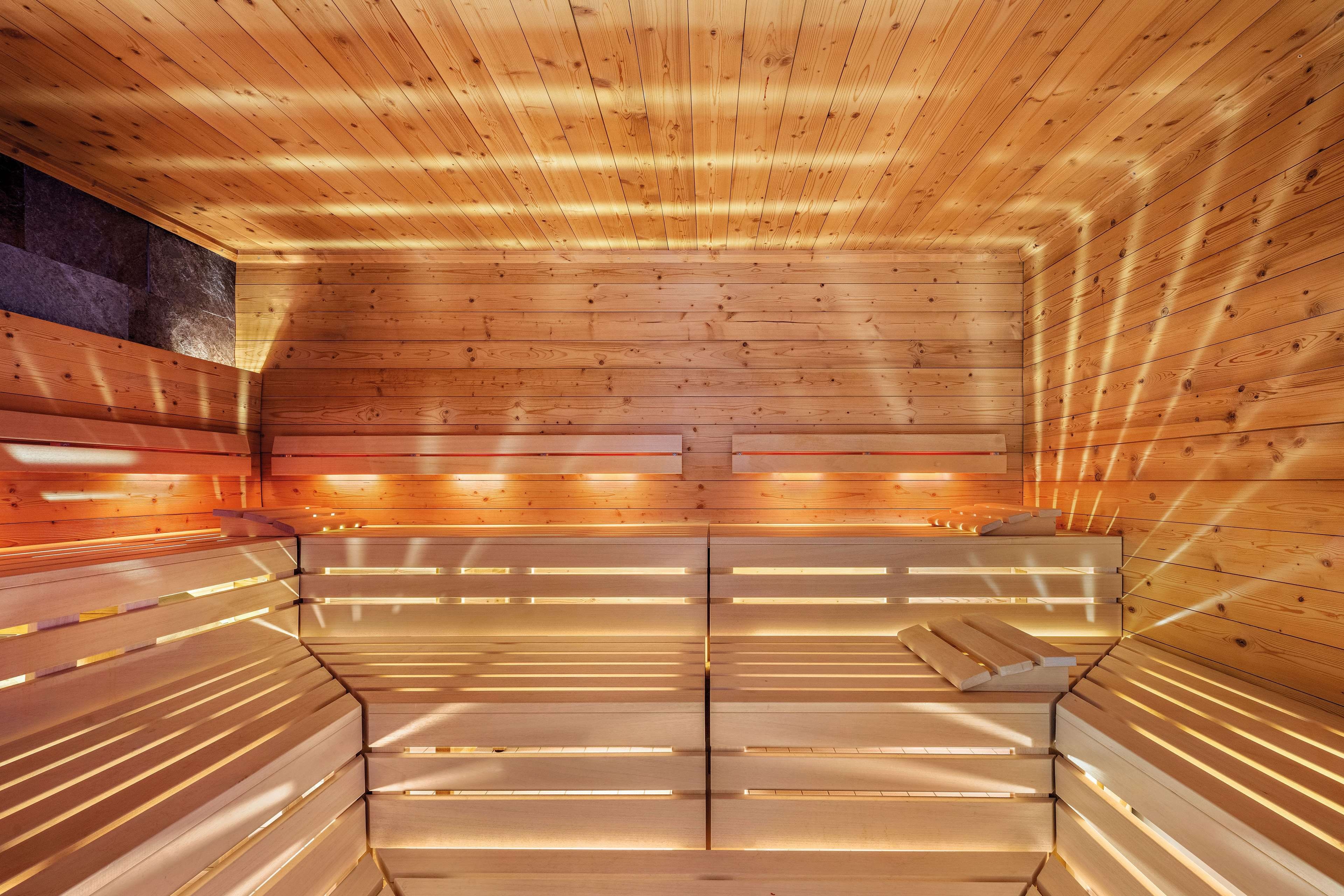 Eine Sauna mit Holzbänken und schräg verlaufender Decke.