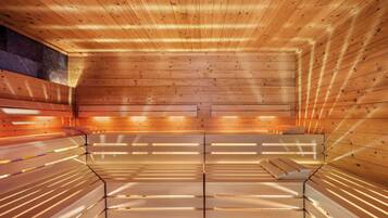 Eine Sauna mit Holzbänken und schräg verlaufender Decke.