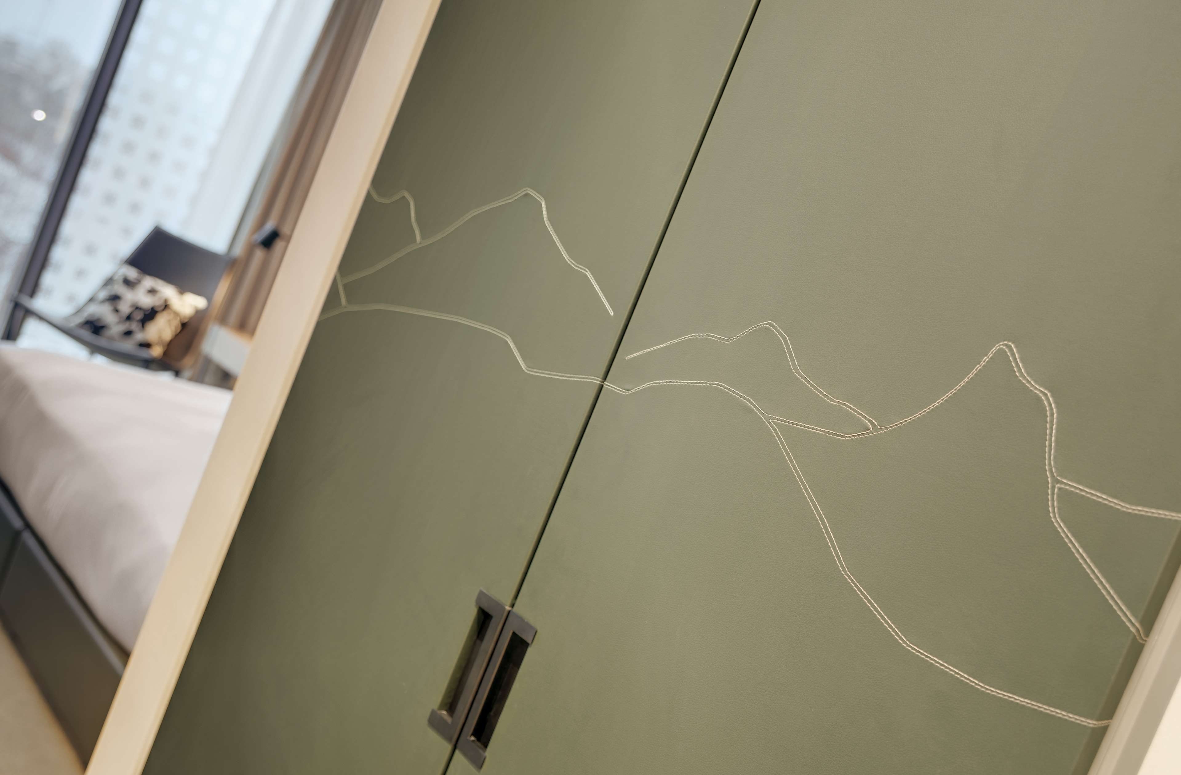 Una habitación con una pared verde y una puerta con un picaporte sencillo.