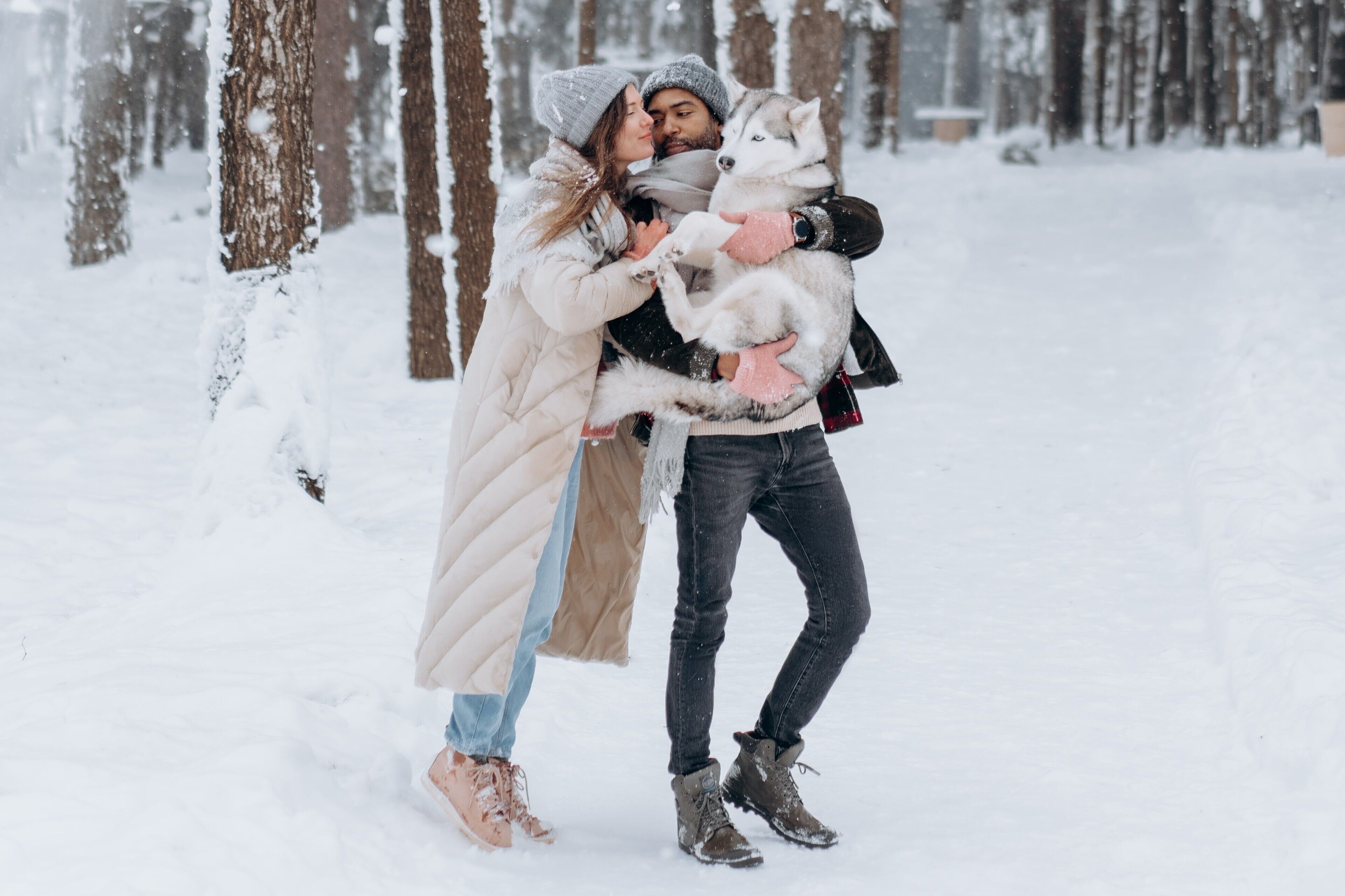 A couple embracing in a snowy forest.