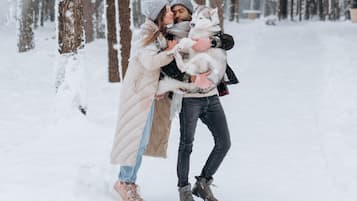 A couple embracing in a snowy forest.