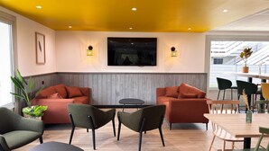A modern interior with two sofas, a small table, and chairs. - Campanile Chambray Les Tours (Chambray-les-Tours)