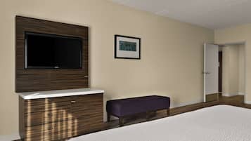 A bedroom with a bed, a TV mounted on a wooden cabinet, a bench, and a door leading to another room.