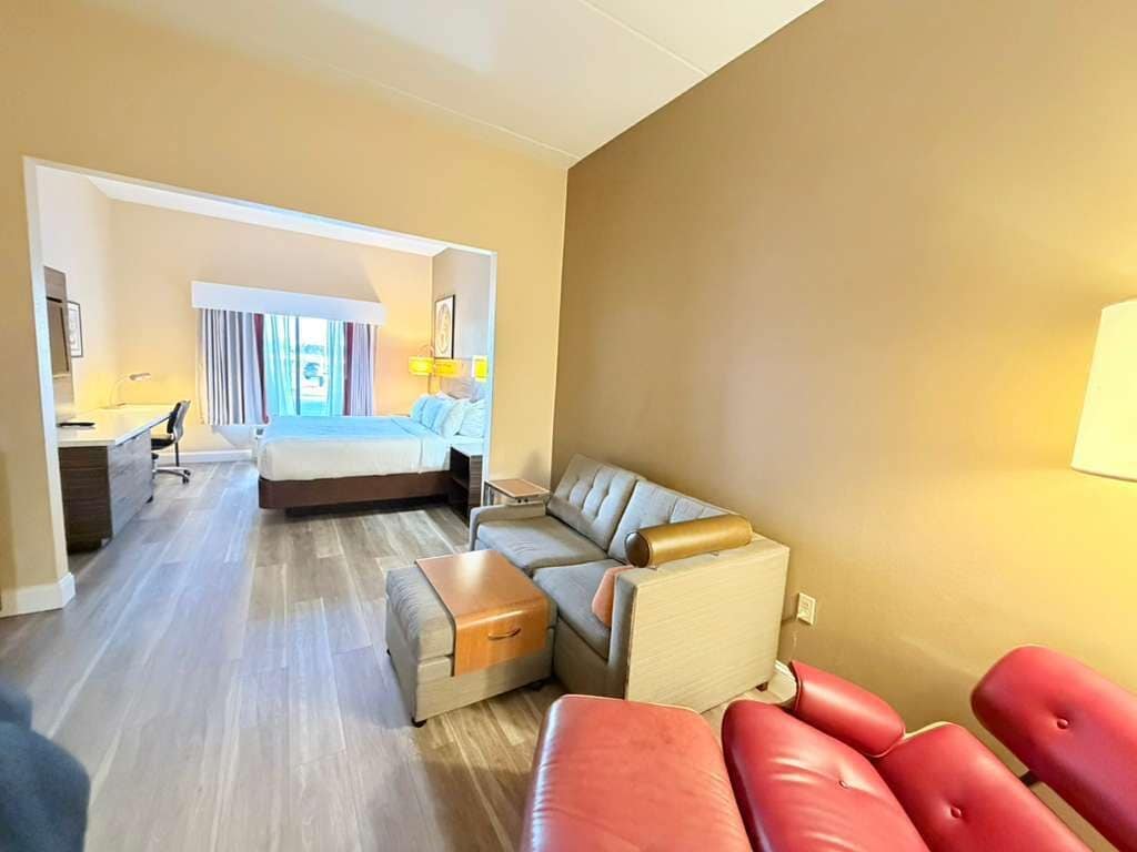Ein Hotelzimmer mit Bett, Sofa, Schreibtisch und Stuhl.