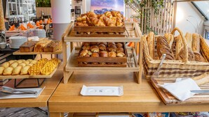 A bakery display with various pastries and bread, including croissants and baguettes, in a modern setting with a view of the cityscape. - Novotel Paris Centre Bercy (Paris)