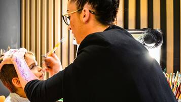 Uma pessoa fazendo um corte de cabelo num salão de beleza, com espelho e diversos instrumentos de cabeleireiro.