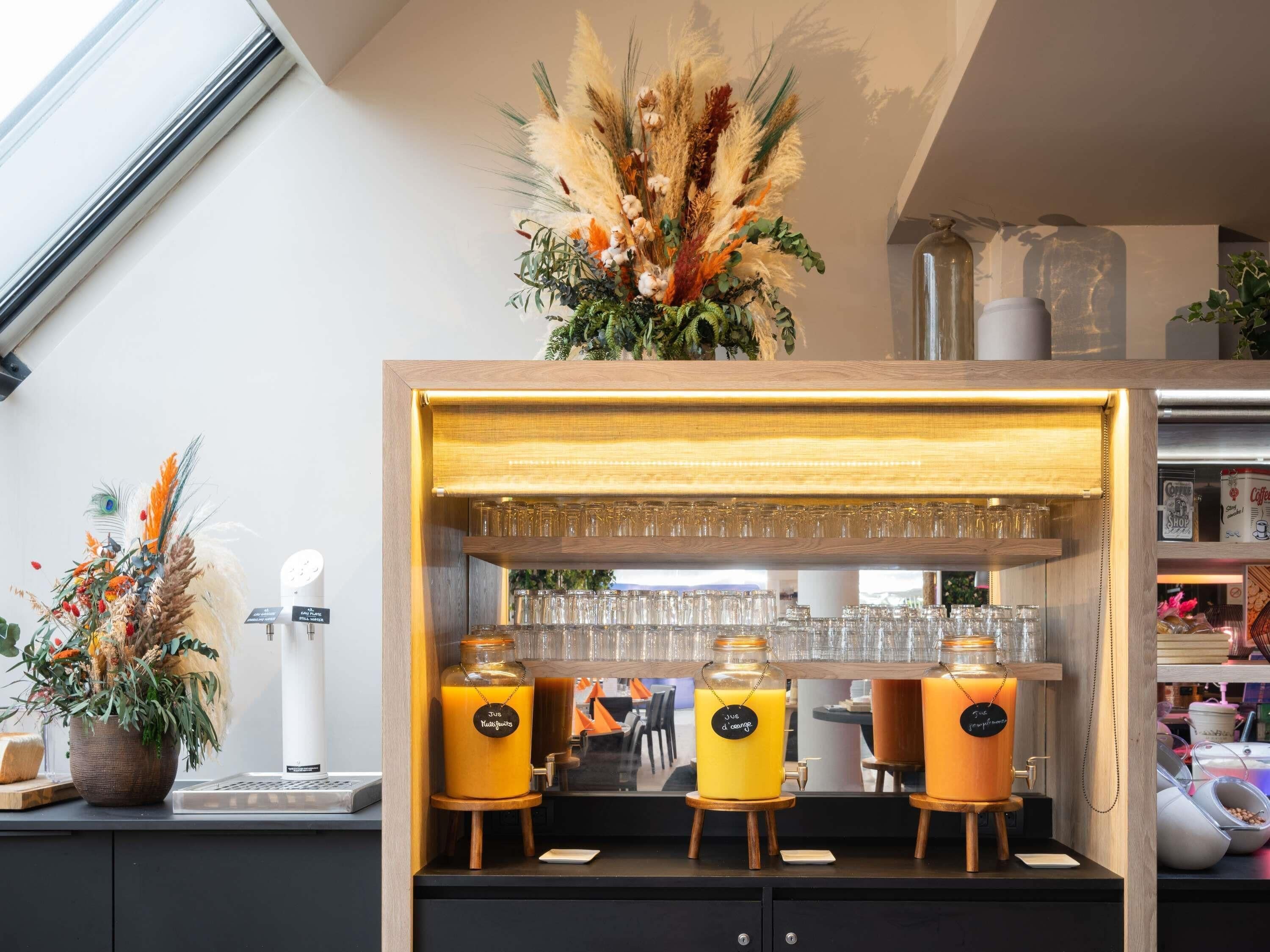 A bar area with a wooden counter, glassware, and two labeled juice dispensers.