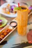 Una mesa de madera con bebidas y alimentos.