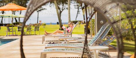 A poolside area with lounge chairs and umbrellas.