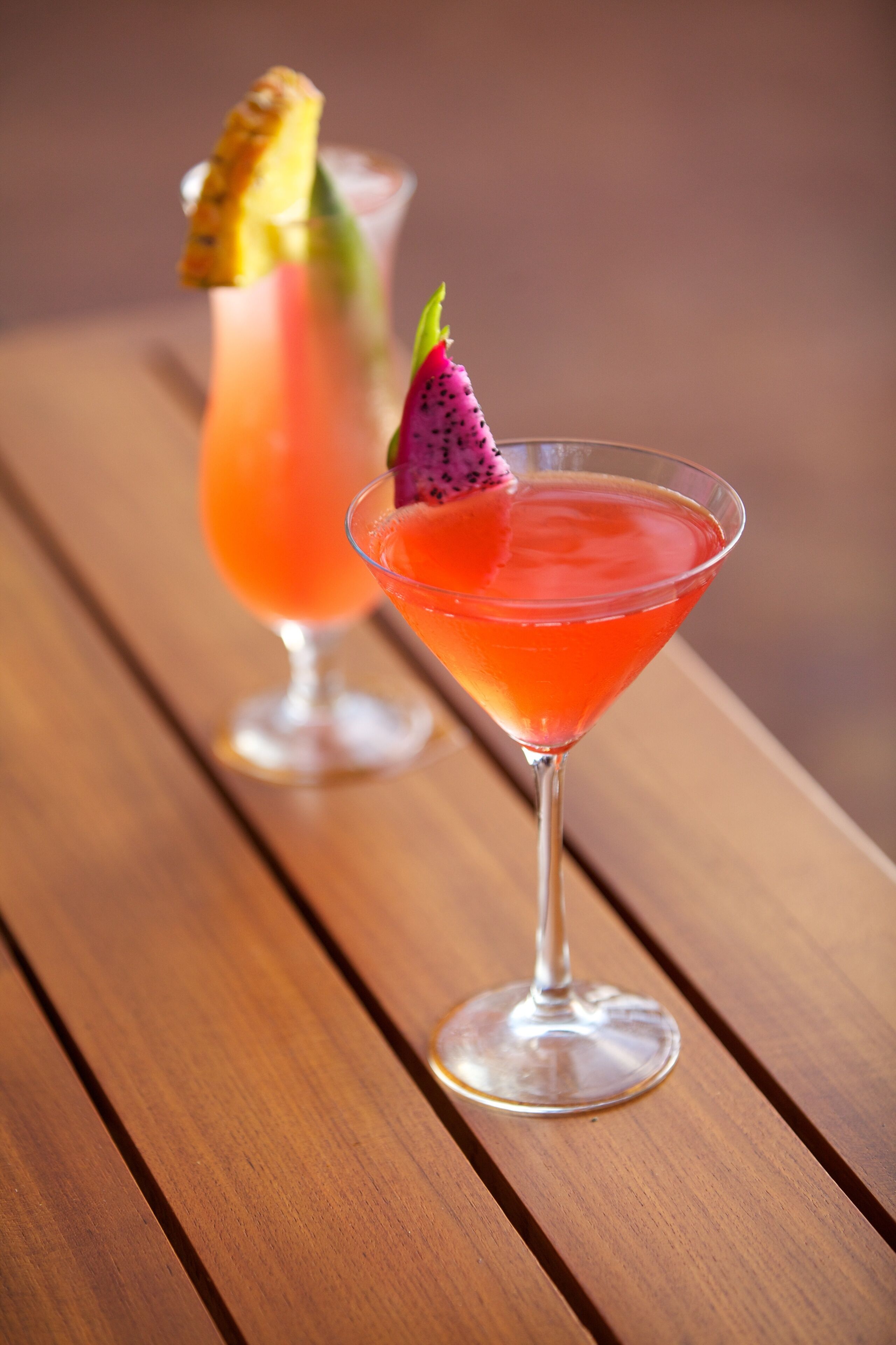 Two cocktails on a wooden table.