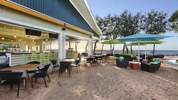Ein Restaurant direkt am Strand mit Außenbereich, einer Bar und Meerblick.