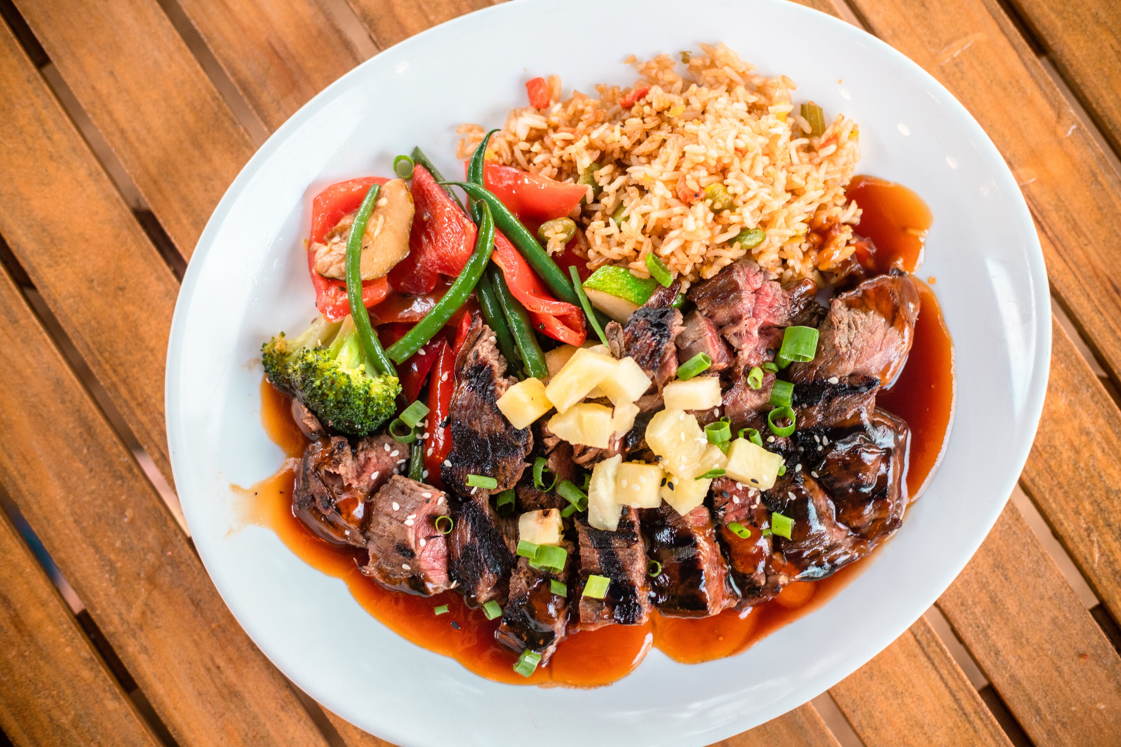 A plate with steak, vegetables, and rice.