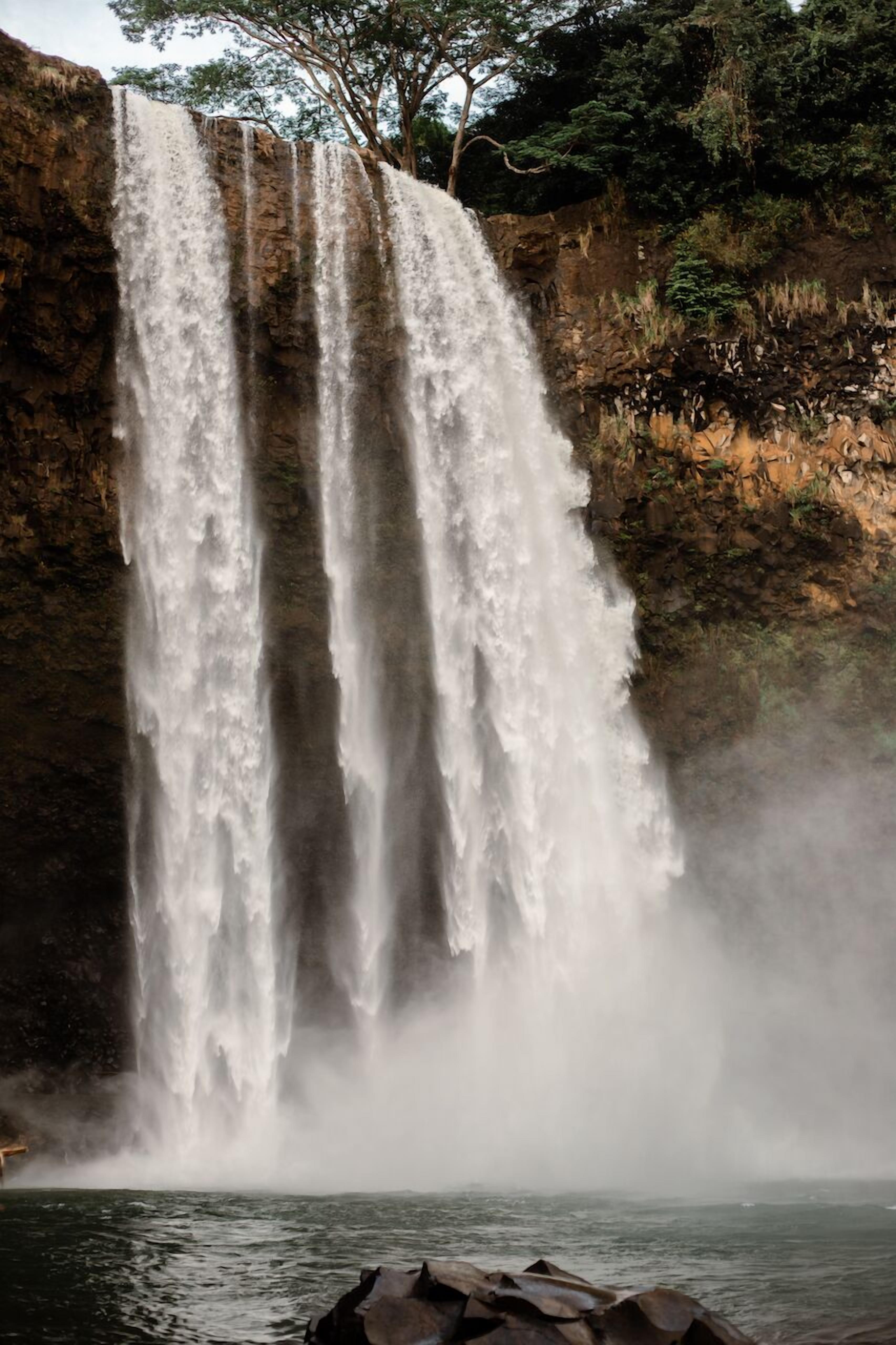 Una cascada se precipita por un risco rocoso hacia una masa de agua.