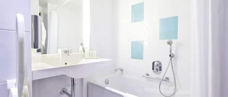 A modern bathroom with a white sink, mirror, and bathtub.