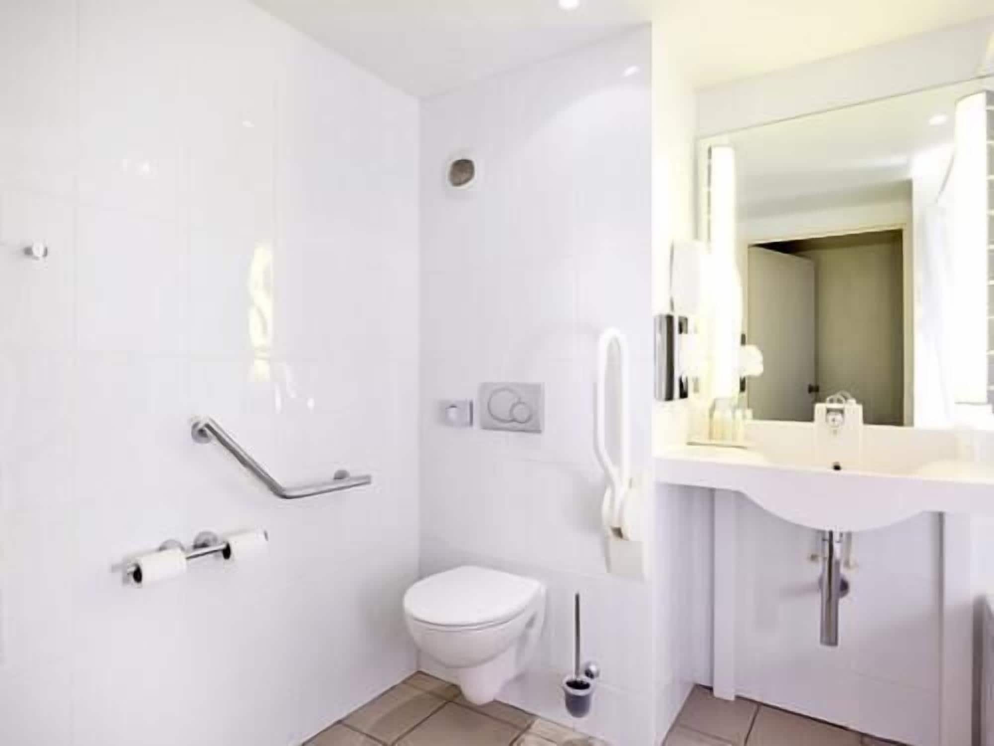 Un baño moderno con inodoro, bidé y zona de ducha.